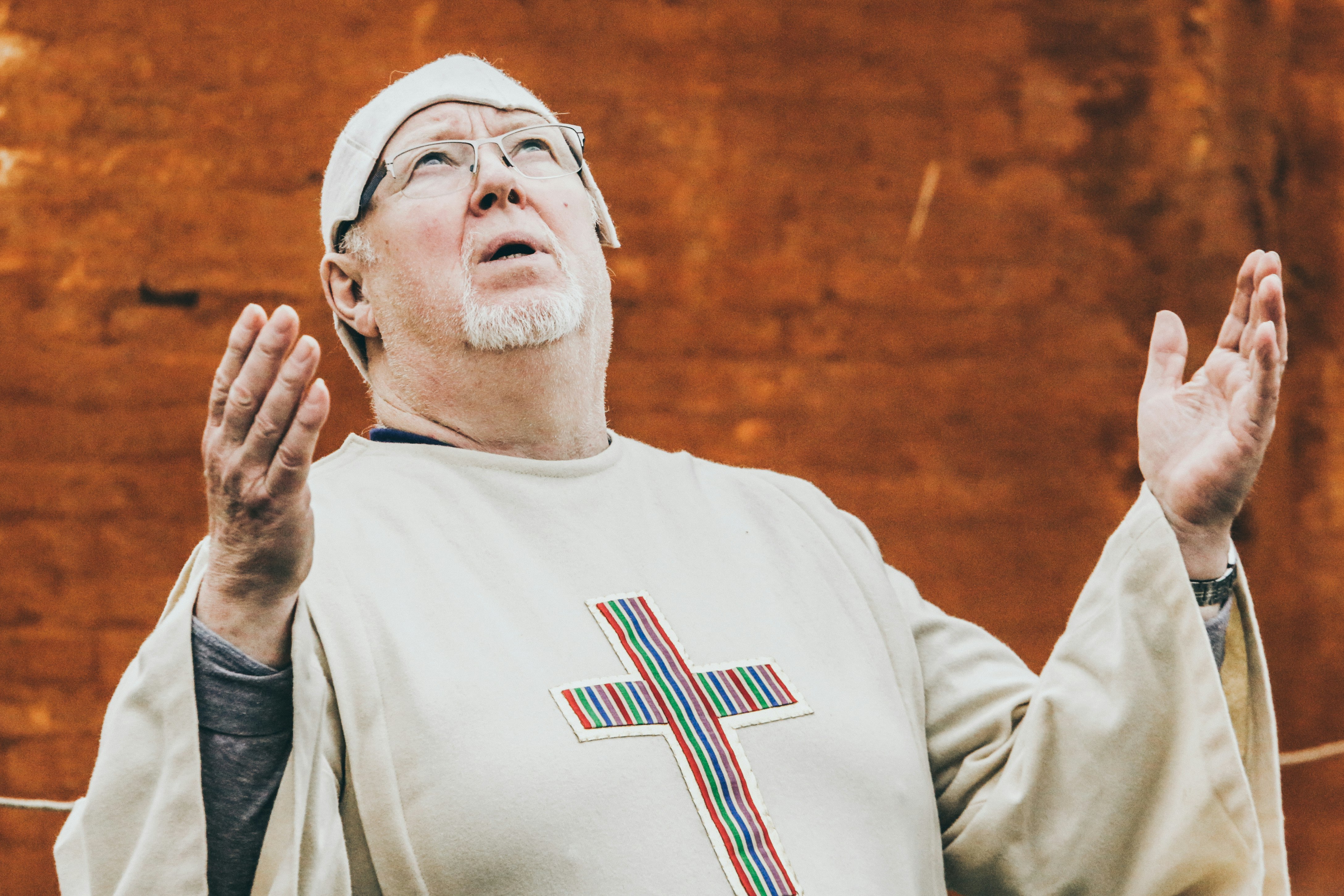 priest standing near brown concrete wall